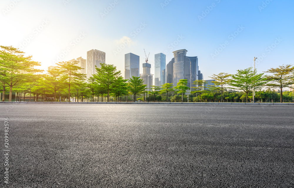 深圳日出时的空沥青路和现代城市商业建筑