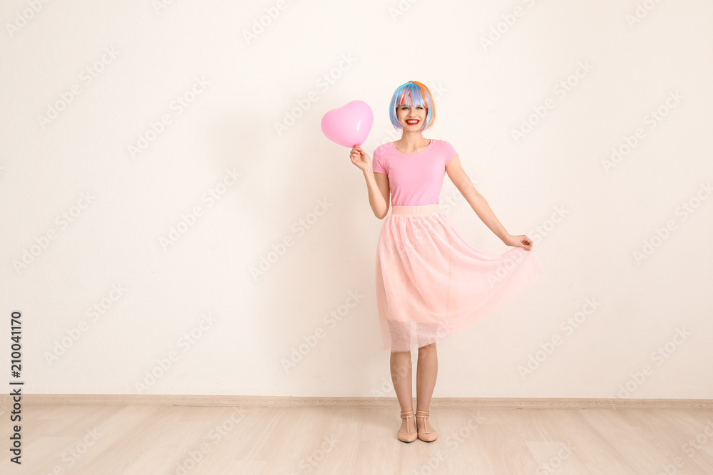 美丽的年轻女子，头发五颜六色，气球顶着光墙