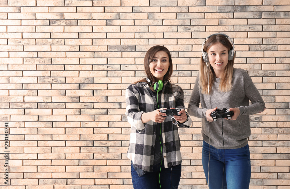 砖墙背景上有游戏手柄的年轻女性