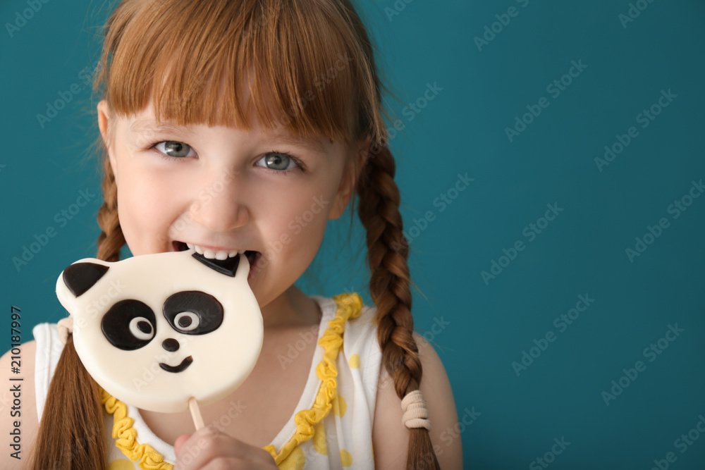 可爱的小女孩在彩色背景上吃棒棒糖