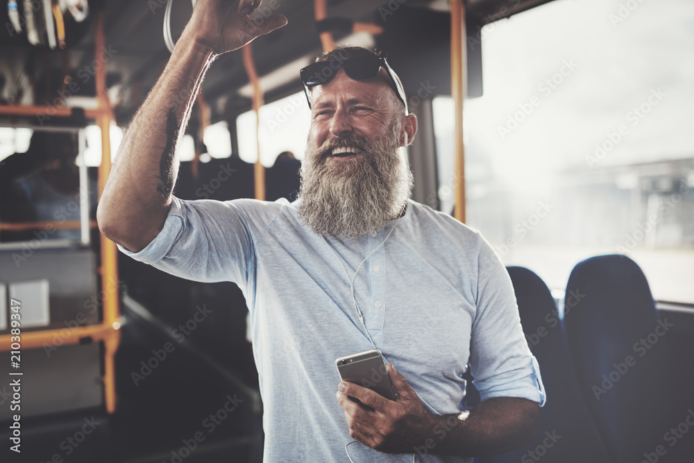 微笑的成熟男人坐公交车听音乐