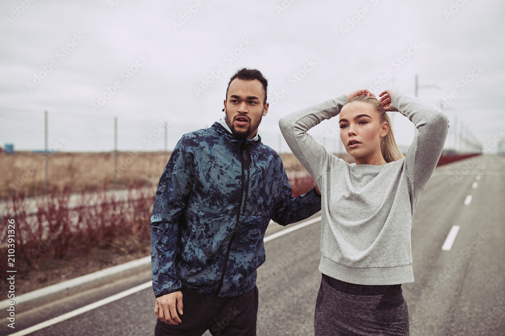 穿着运动服的年轻夫妇站在乡间小路上