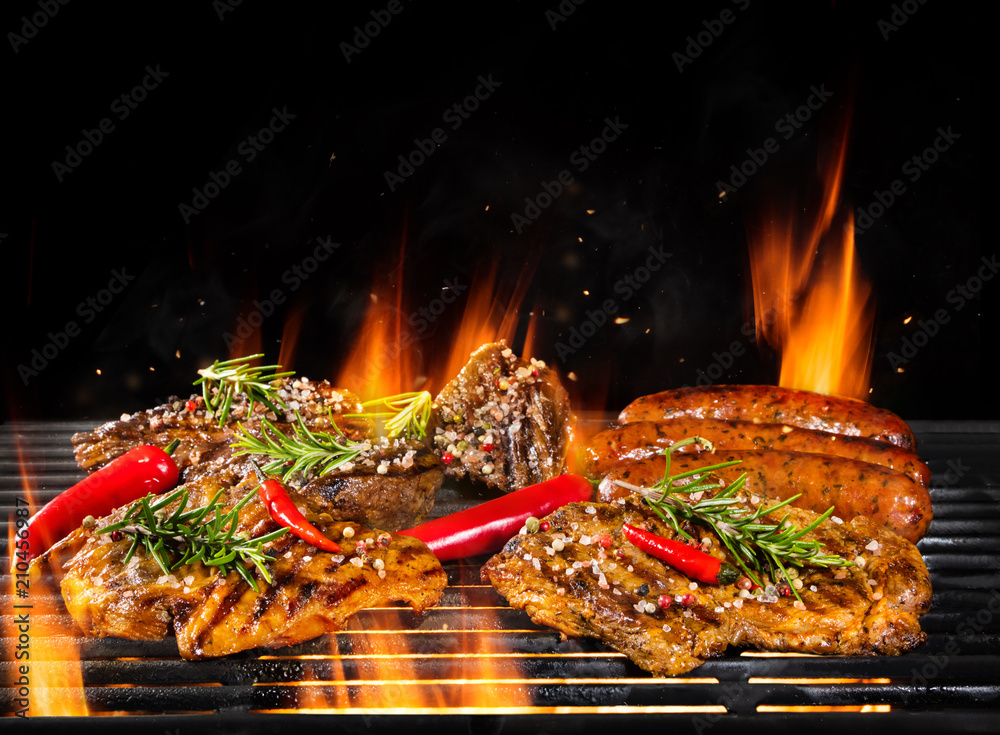 各种各样的肉被烤，在黑色上隔离