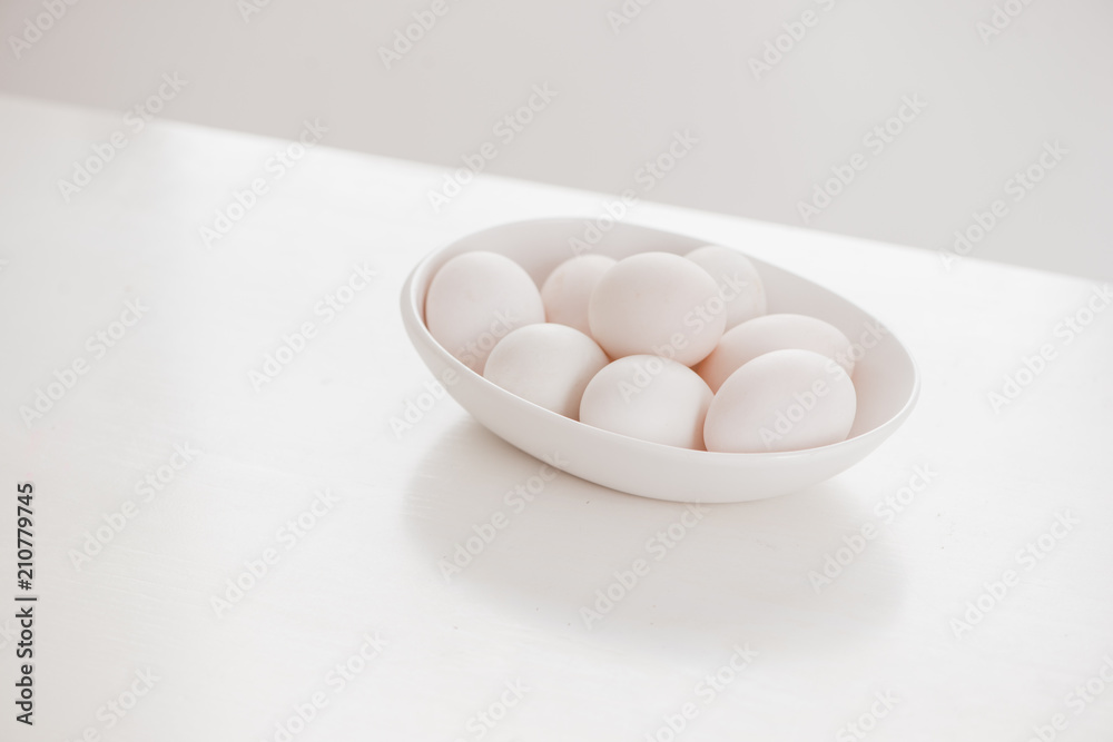 木桌上的白色盘子里的鸡蛋
