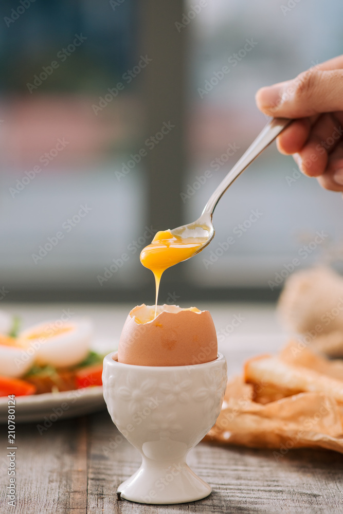 木板上刚煮好的白鸡蛋。健康的健身早餐。