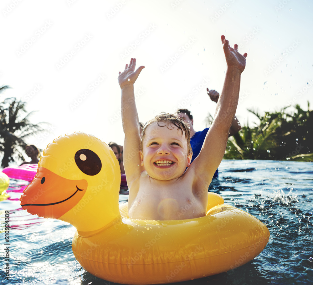 快乐男孩和游泳池里的黄色鸭子管
