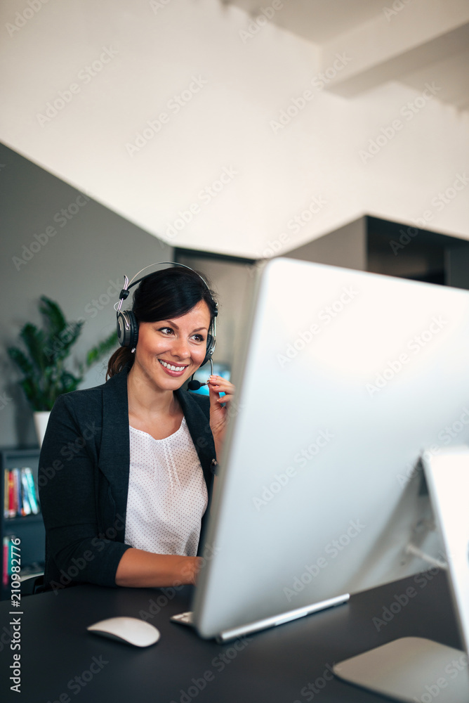 Female customer support operator with headset working.