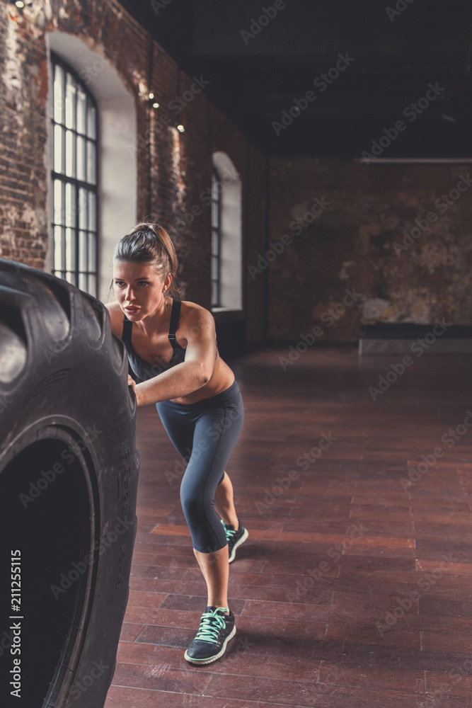 Sports girl with a wheel in workout