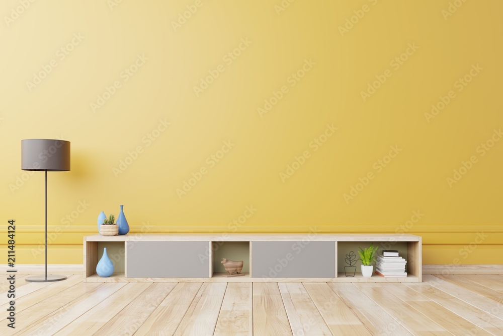 现代客厅的电视柜或放置物品的柜子，黄色墙上有灯、桌子、花草