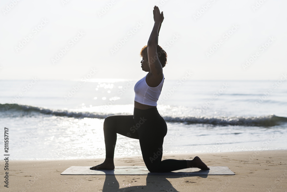 非洲裔美国妇女在海滩练习瑜伽