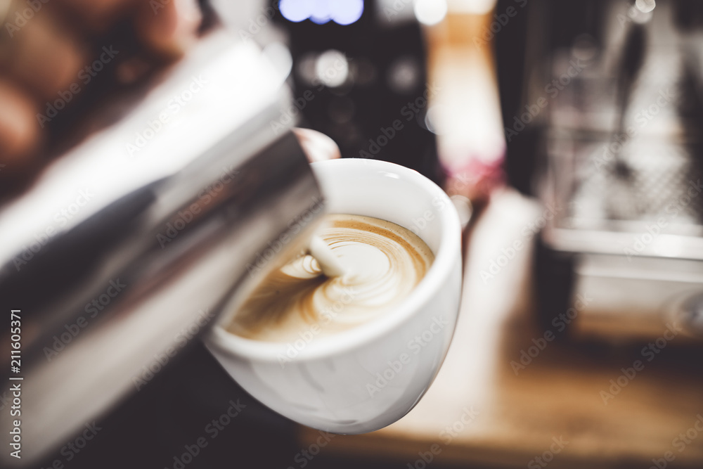 咖啡拿铁艺术，咖啡师把牛奶倒进杯子里