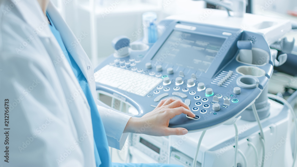 在医院，产科医生在启动超声波/Sonogra之前按下控制面板上的按钮