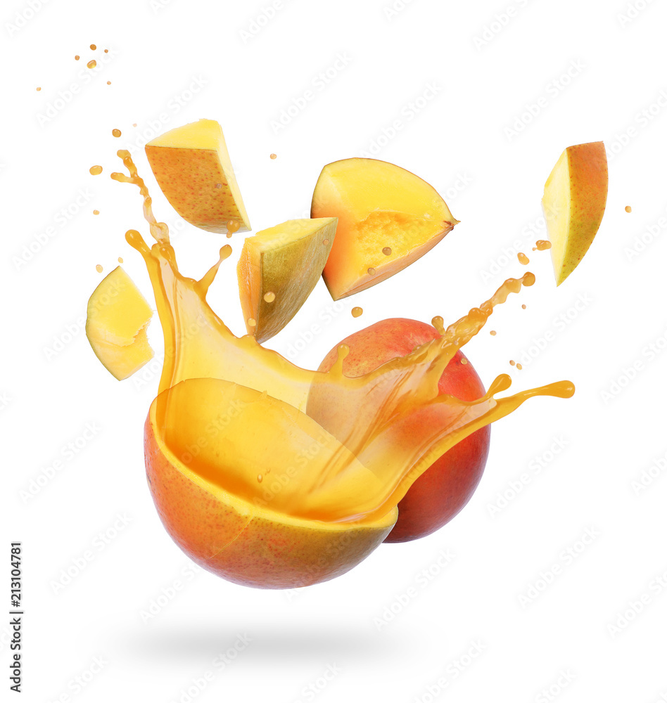 Mango broken into pieces with splashes of juice on white background