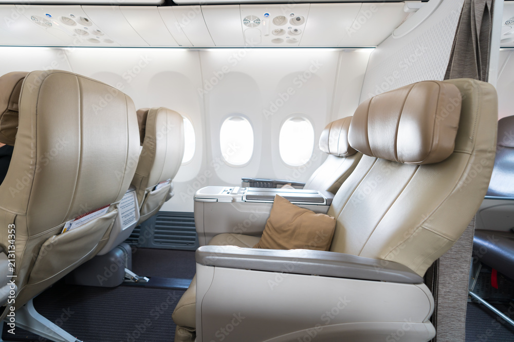 飞机商务舱倾斜座椅上的一排空皮革座椅。
