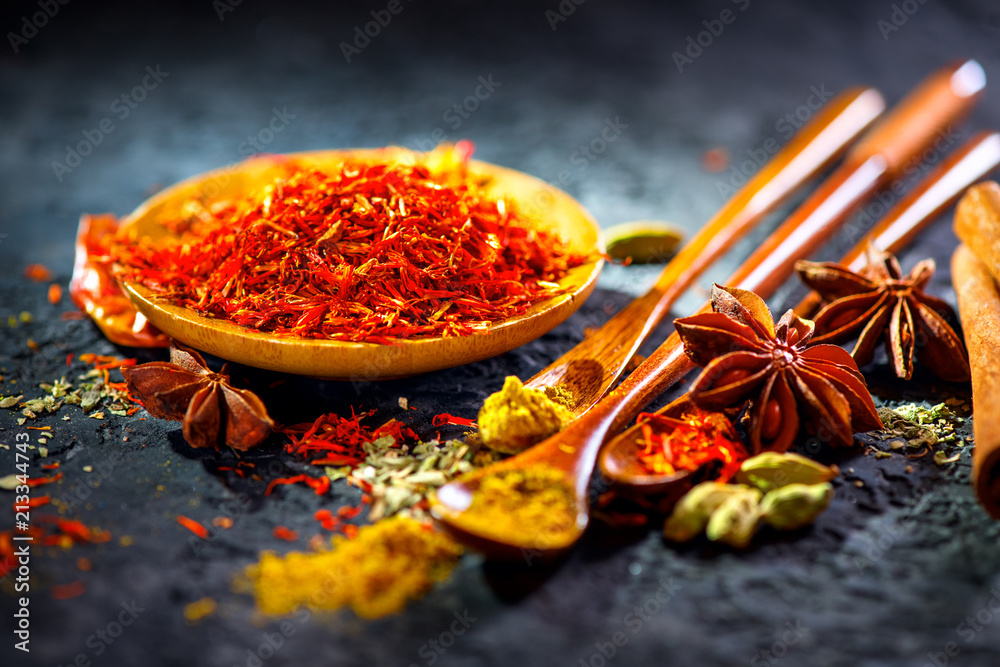 藏红花。黑石桌上的各种印度香料。石板背景上的香料和香草。烹饪