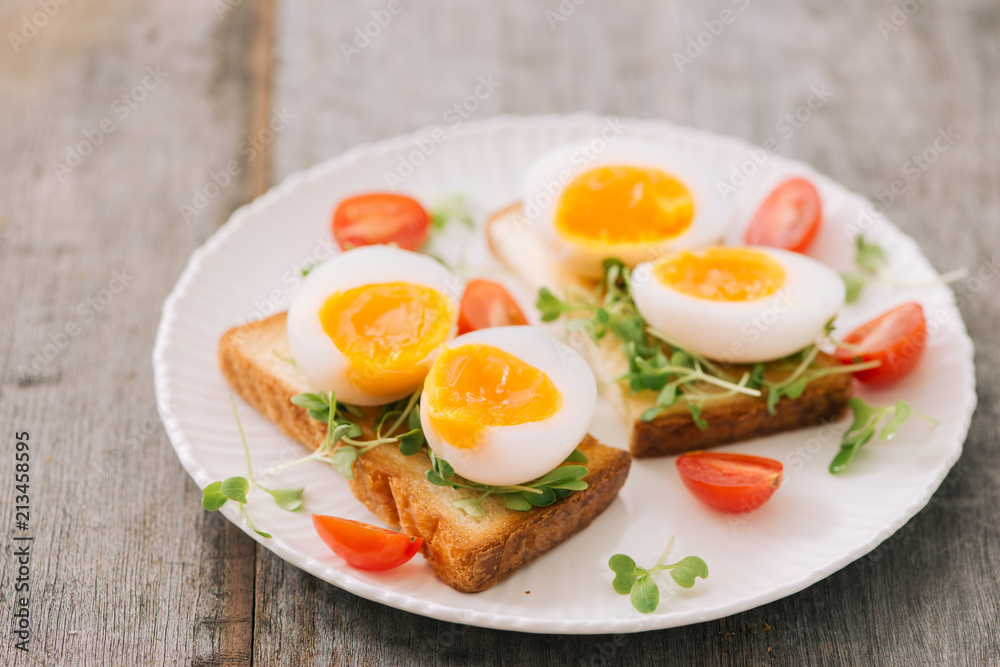 木板上刚煮好的白鸡蛋。健康的健身早餐。