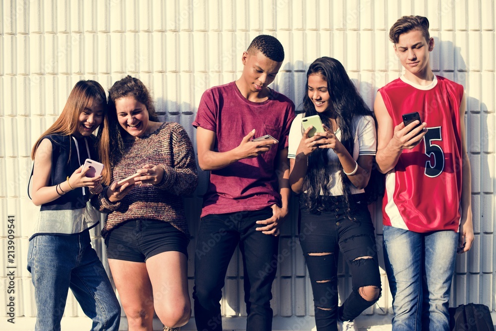 一群年轻的青少年朋友一起使用智能手机社交媒体概念放松身心