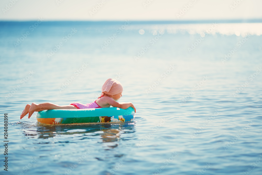 三岁女孩乘船在海滩玩耍。孩子在海上家庭度假