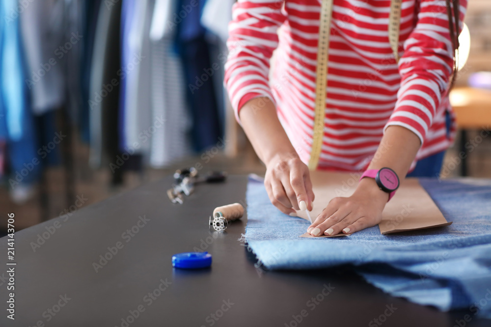 年轻的女裁缝在工作室里用缝纫图案工作