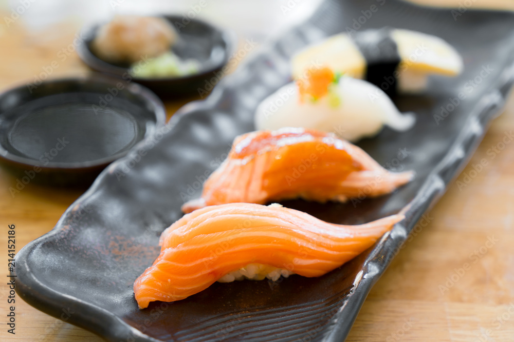 日本料理的特写——黑盘子里的日本寿司配芥末和日本酱油