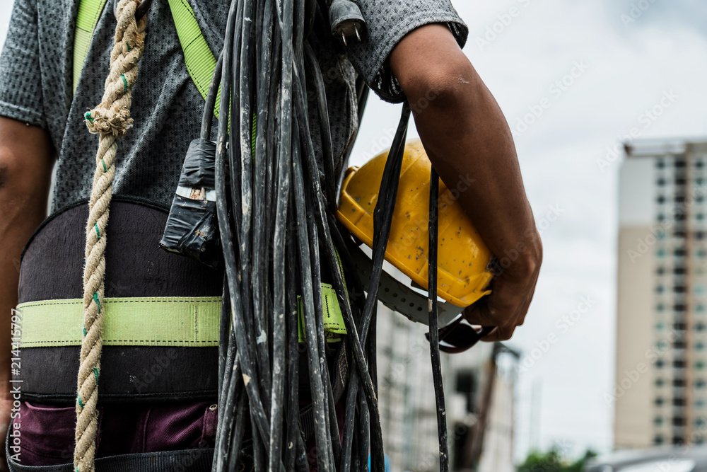 带头盔和皮带工具的承包商工人，以建筑翻新现场施工为背景