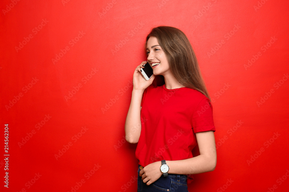 美丽的年轻女子在彩色背景下用手机聊天