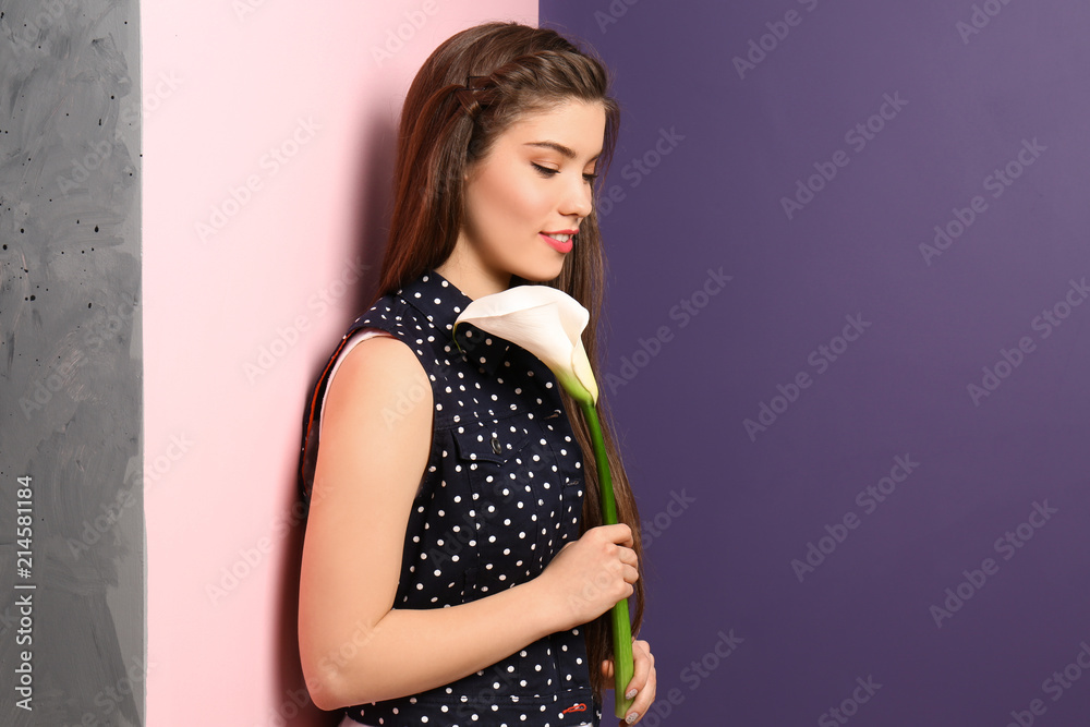 美丽的年轻女子，在彩色墙附近有花