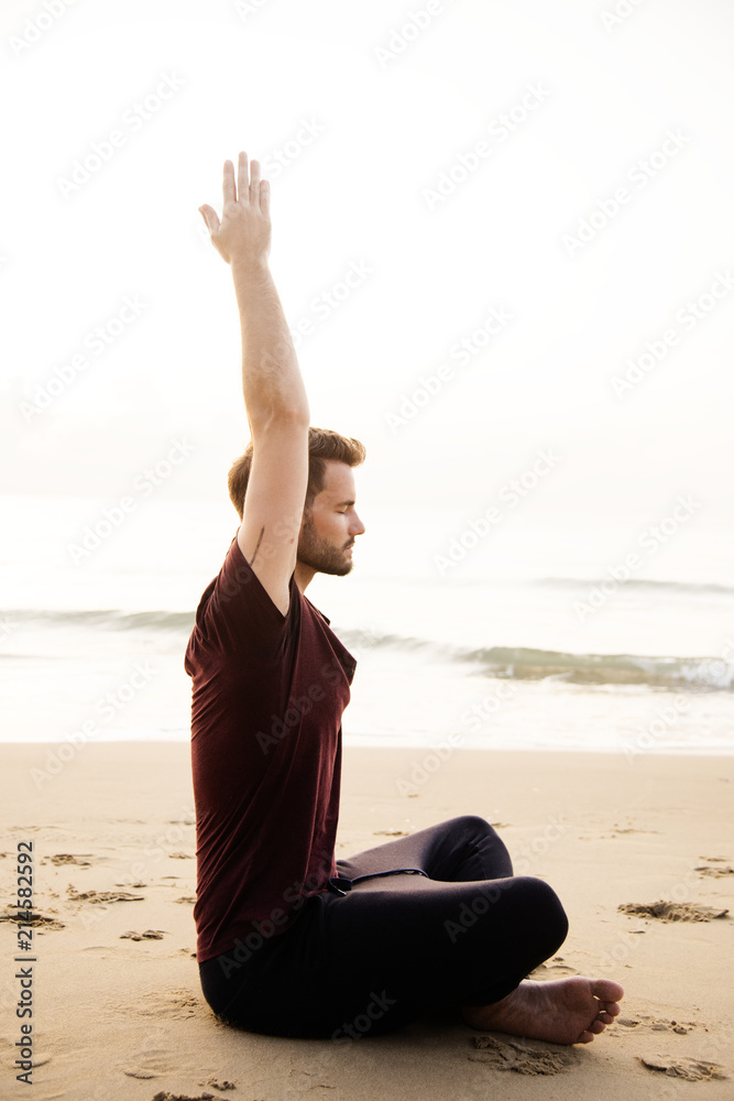 男子在海滩上练习瑜伽
