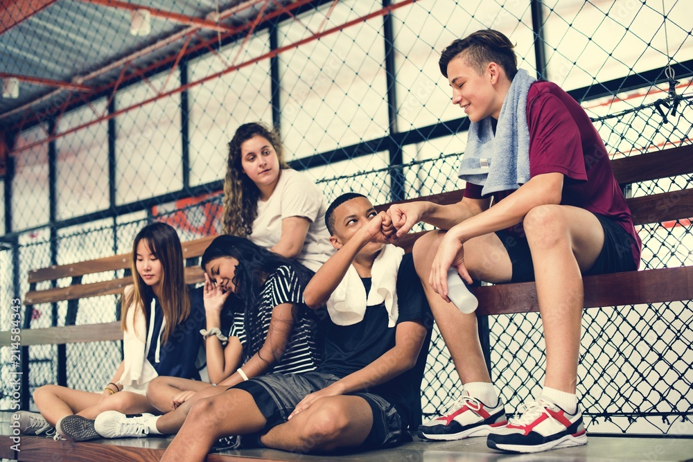 一群年轻的青少年朋友坐在长椅上放松