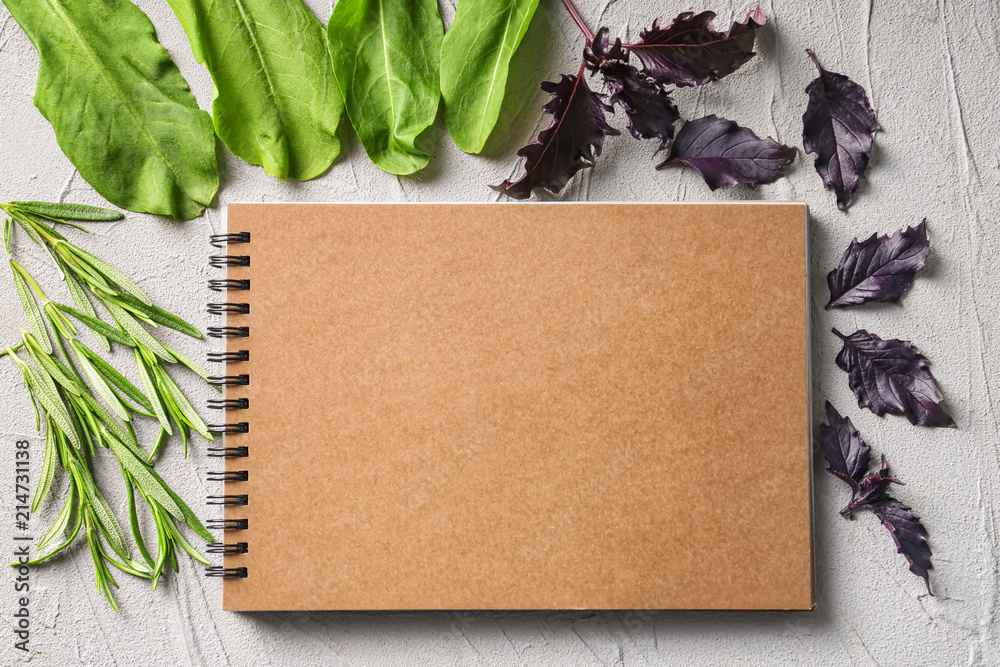Composition with fresh herbs and notebook on textured background