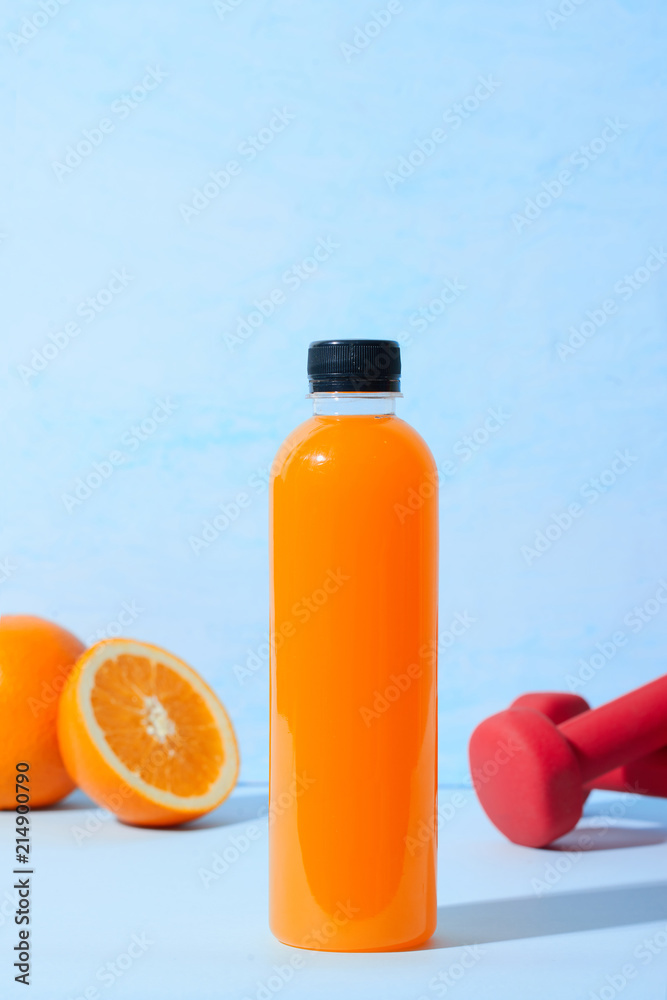 桌上有哑铃的新鲜天然橙汁。健康饮料。