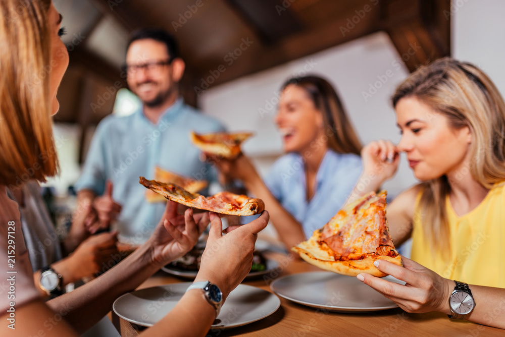 一群朋友或同事吃披萨的特写图像。