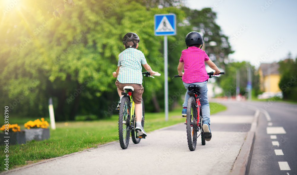 带着背包的孩子在学校附近的公园里骑自行车。小学生在户外背着背包