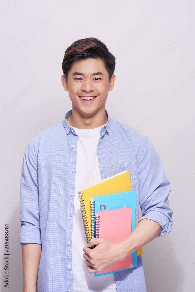 Confident asian handsome student holding books