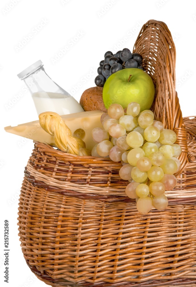 野餐篮里的奶酪、苹果、葡萄、面包卷和牛奶-