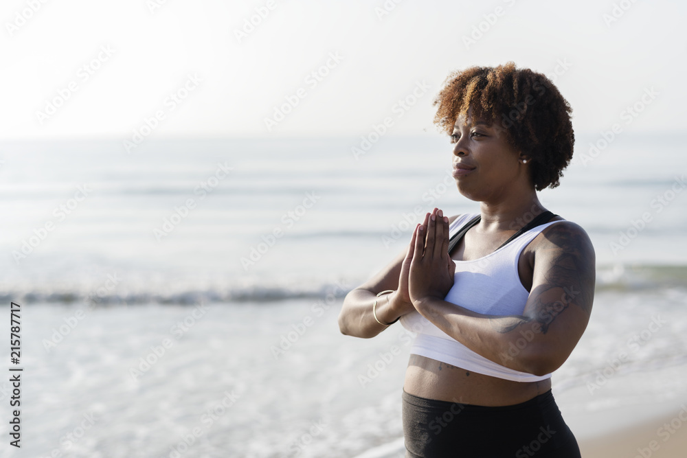 在海滩练习瑜伽的非洲裔美国女性