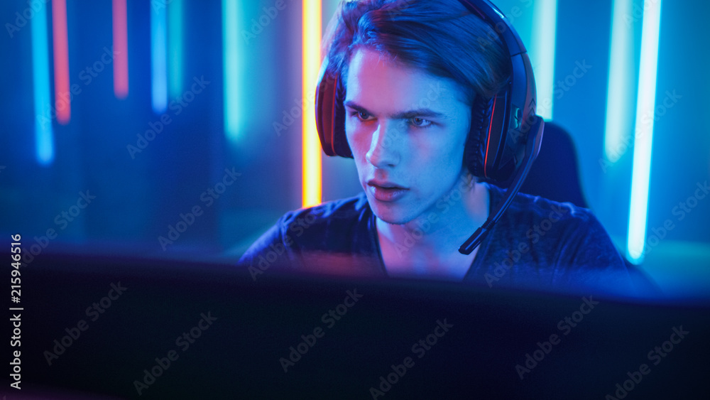 年轻的职业玩家玩在线电子游戏，通过麦克风与团队玩家交谈。霓虹灯颜色
