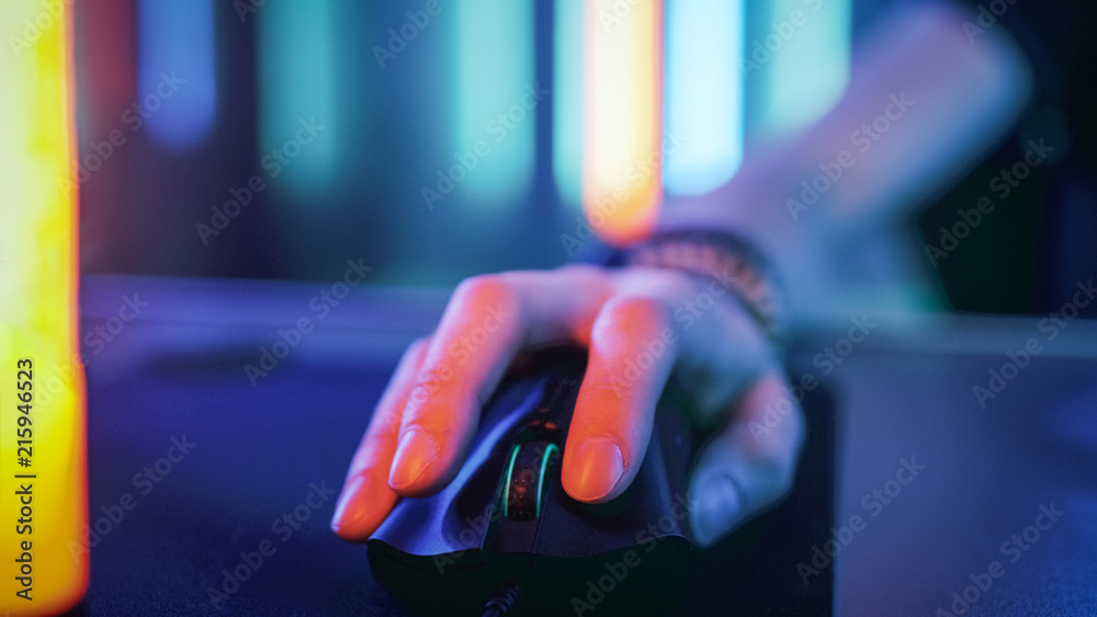 特写使用电脑鼠标的手。炫酷的霓虹复古灯。在互联网或Playi中浏览
