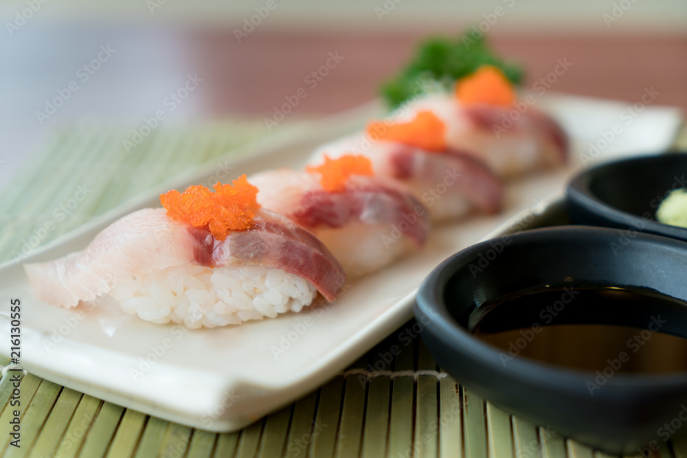 白盘子里的滨池寿司，配日本酱汁和绿叶装饰，日本食物，clo