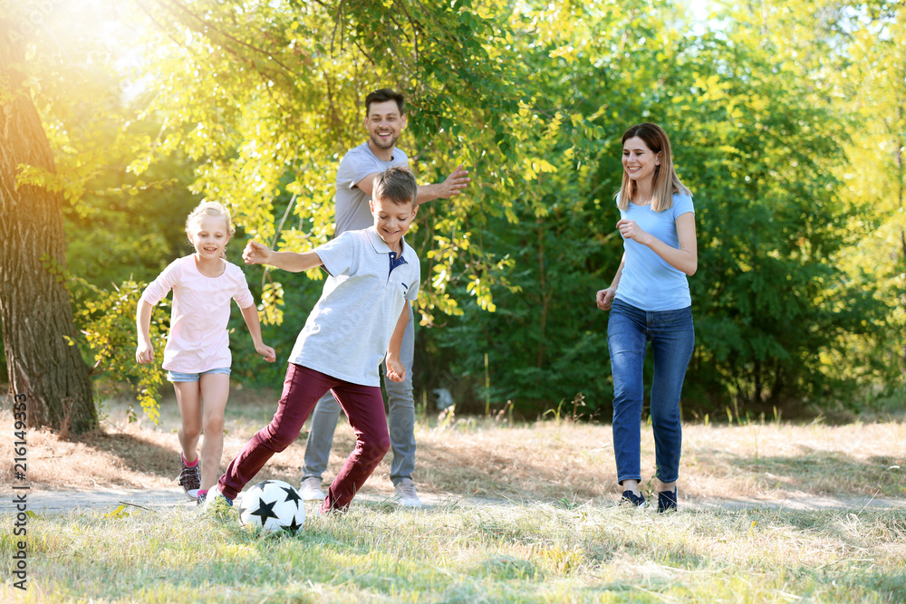 快乐的家庭在户外踢足球