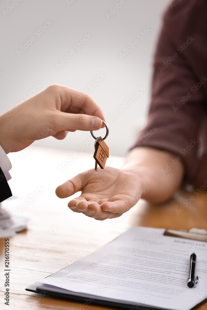 房地产经纪人将新房钥匙交给上班族