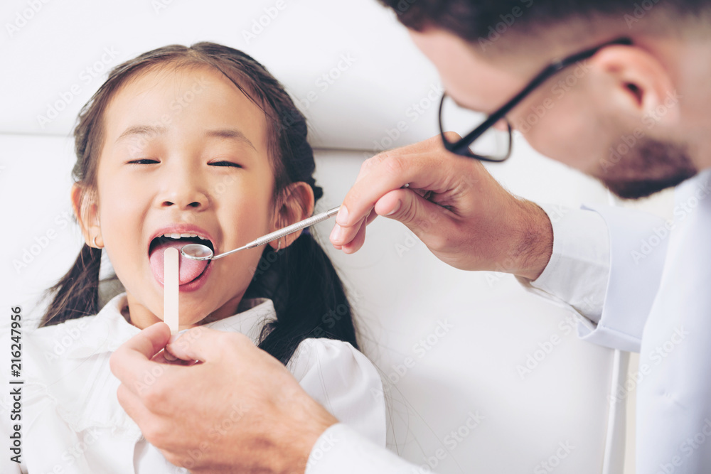 Dentist examining child teeth in dental clinic.