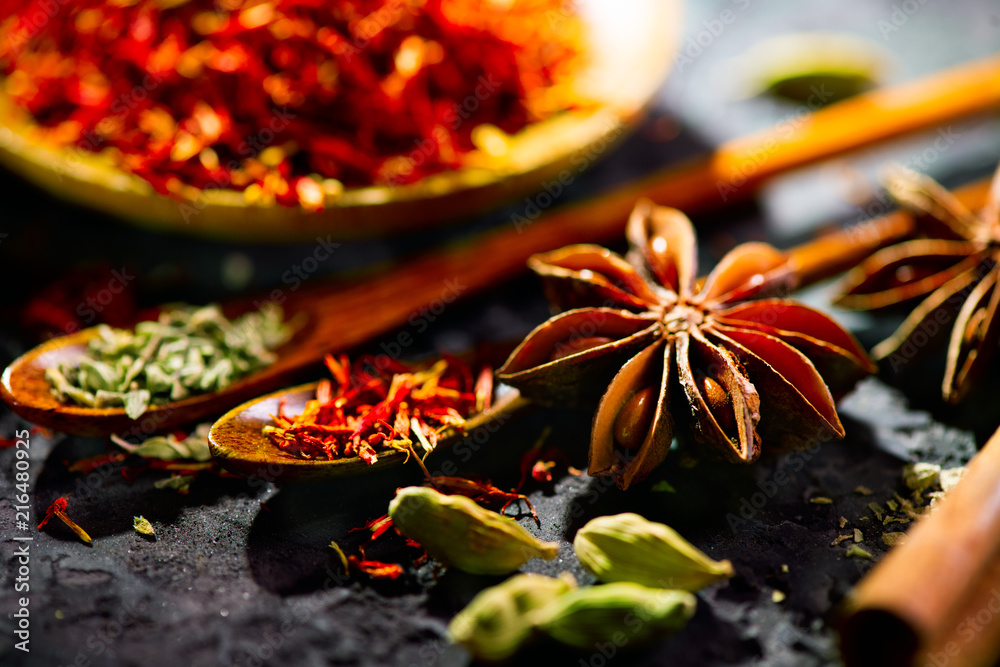 香料。黑石桌上的各种印度香料。石板背景上的香料和香草。烹饪