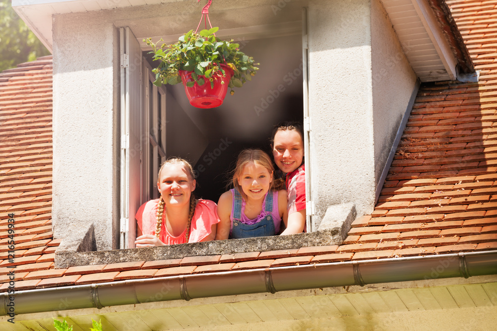 打开的阁楼窗户里三个微笑的女孩