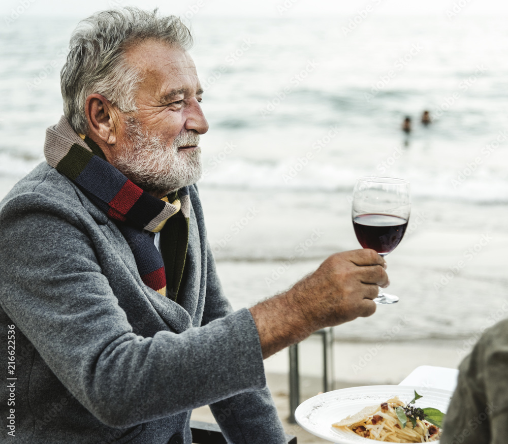 老年人在海滩上用红酒敬酒