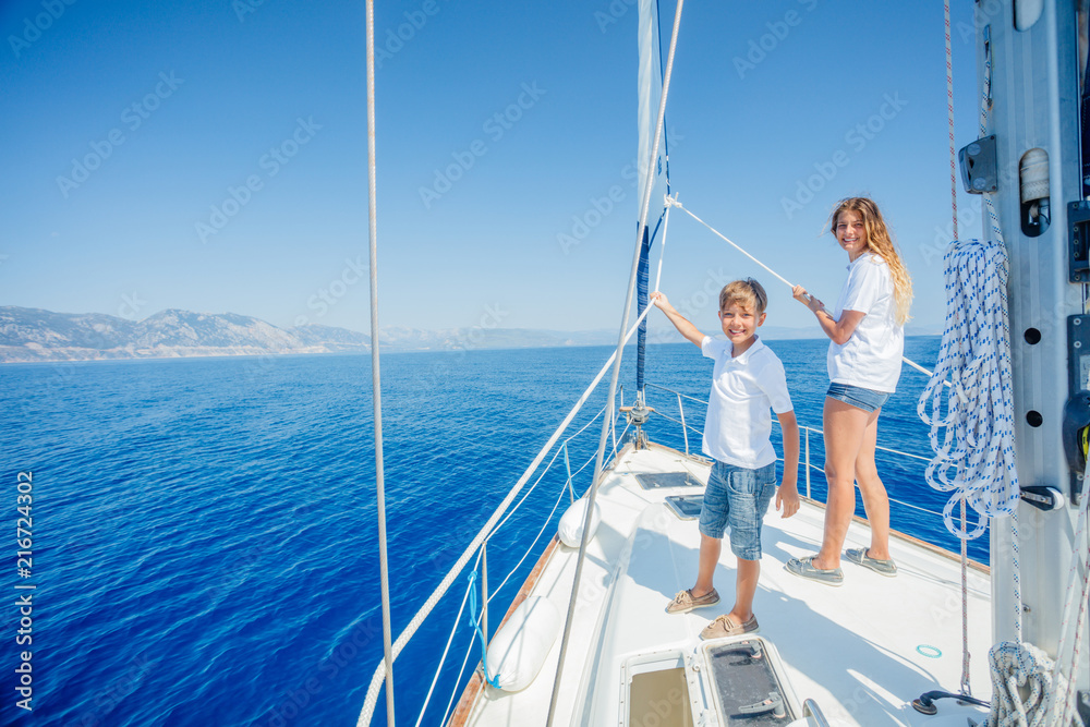 男孩和他的妹妹在夏季游轮上的帆船上。
