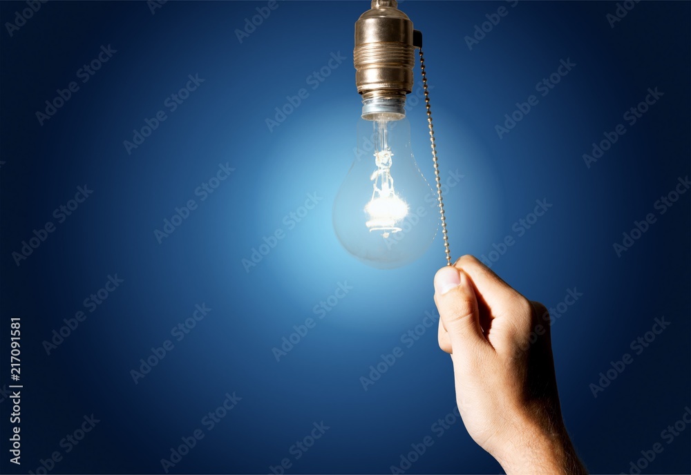 Hand turning off the bulb lamp.Turning off