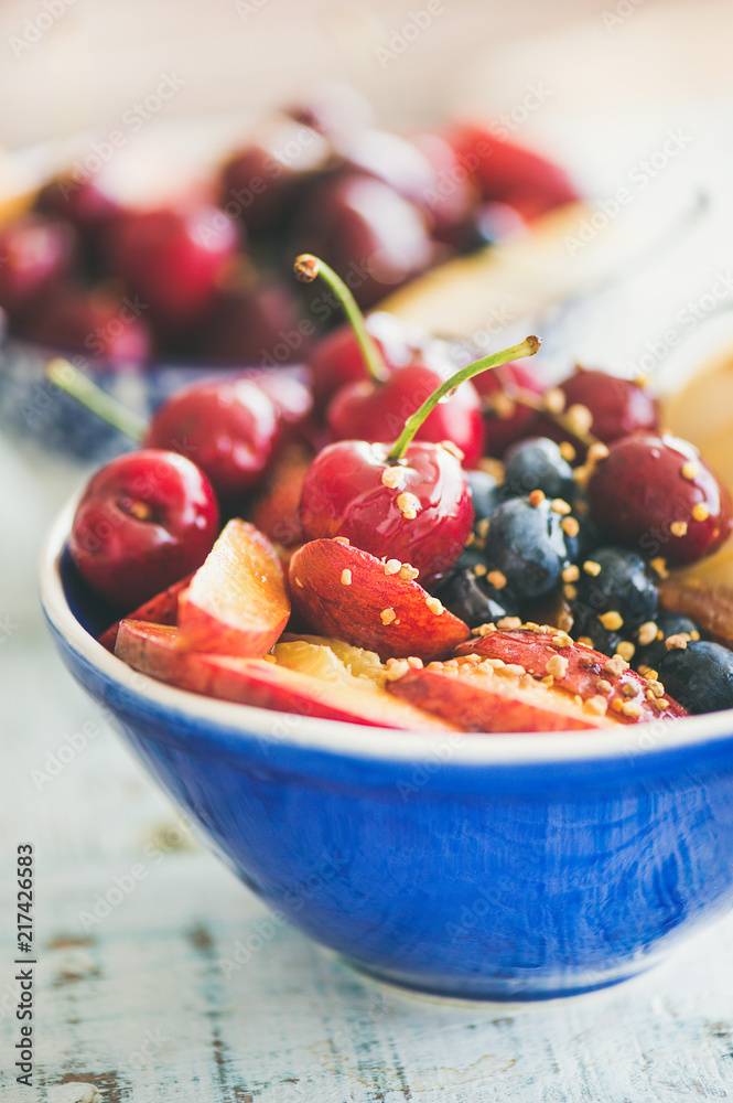 健康的早餐奶昔碗，木质背景上有新鲜水果和浆果、蜂花粉和蜂蜜