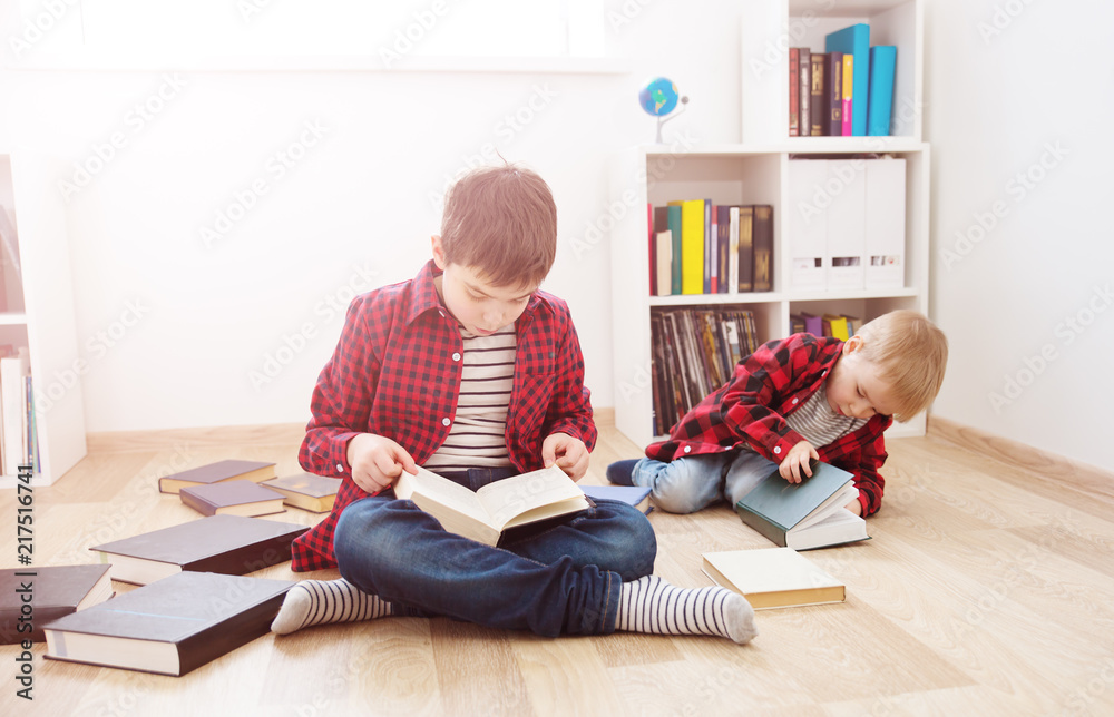 三岁的孩子坐在家里的书中间