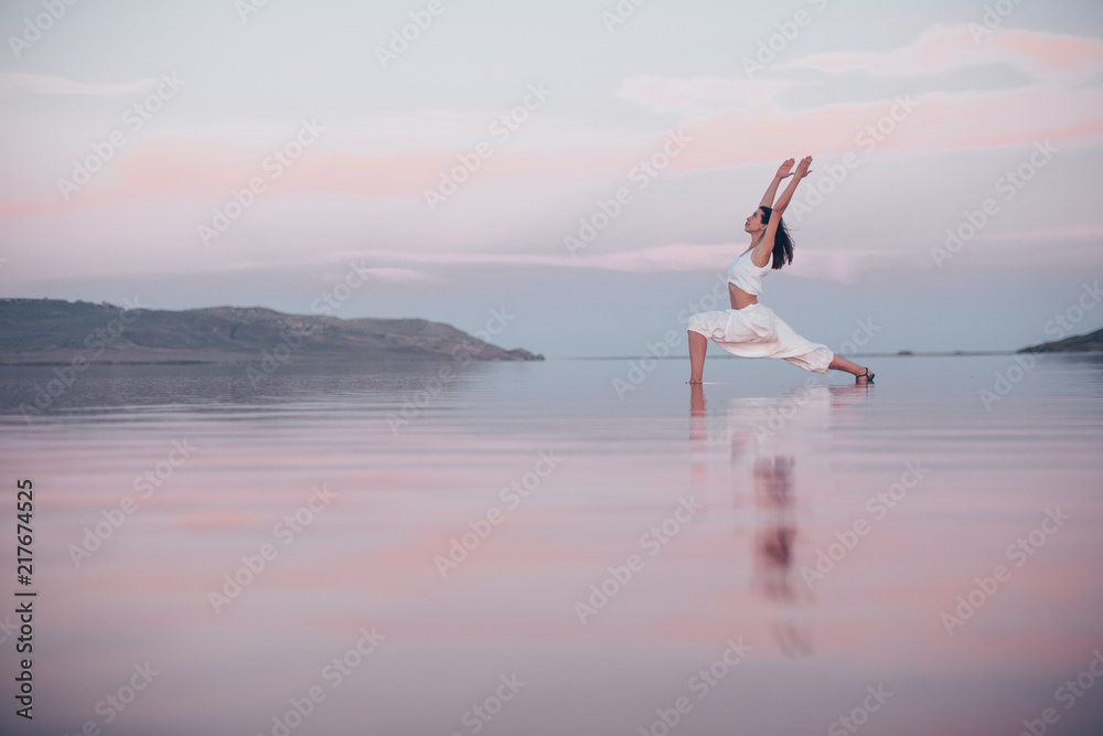 Young woman doing yoga at the lake